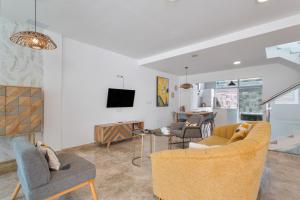 a living room with a couch and chairs and a tv at Casa Alicia in Corralejo