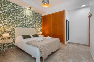 a bedroom with a bed and a floral wall at Casa Alicia in Corralejo +27 photos