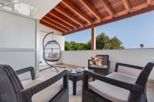 a patio with chairs and a table and a swing at Casa Alicia in Corralejo
