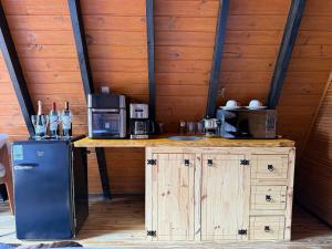 a kitchen with a counter with a refrigerator and microwave at Chalet with Private Jacuzzi and View of the Jucu River in Domingos Martins