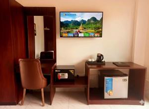 Una habitación con un escritorio y un televisor en la pared. en Intimate Riverside Resort, en Vang Vieng