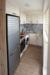 a kitchen with a stainless steel refrigerator and a dishwasher at Апартамент за гости 2 Тракия Плаза in Shumen