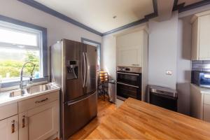 a kitchen with a stainless steel refrigerator and a sink at Hamara Luxury Portree Cottage with Hot Tub! in Portree