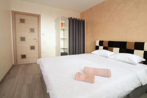 a bedroom with a white bed with two towels on it at Апартамент за гости 2 Тракия Плаза in Shumen