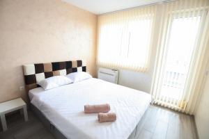 a bedroom with a large bed with two towels on it at Апартамент за гости 2 Тракия Плаза in Shumen