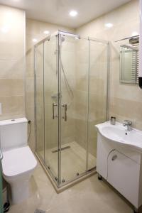 a bathroom with a shower and a toilet and a sink at Апартамент за гости 2 Тракия Плаза in Shumen