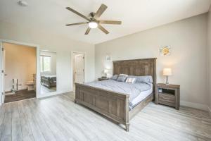 Un dormitorio con una cama y un ventilador de techo. en Grass Lake 8BR Retreat w Games & Fire Pit, en Grass Lake