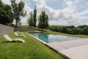 a swimming pool in a yard with two lawn chairs at Chateau Erigoye in Beychac-et-Caillau