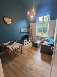 een woonkamer met een tafel en een bank bij Kindermann Residence in Łódź
