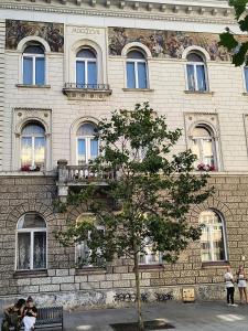 a building with people sitting on a bench in front at Kindermann Residence in Łódź