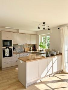 テルクテにあるWohlfühloase nähe Münster - Ruhige 120qm Wohnungの白いキャビネットとキッチンアイランド付きのキッチン