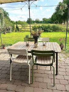 テルクテにあるWohlfühloase nähe Münster - Ruhige 120qm Wohnungの木製テーブル(椅子2脚付)と花のテーブル +7枚の写真