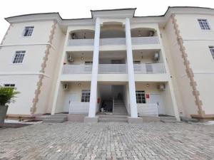 a large white building with columns in front of it at Hometime Utako in Abuja