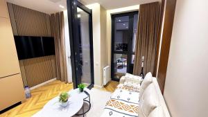 a living room with two couches and a television at Nest One Parkside in Tashkent