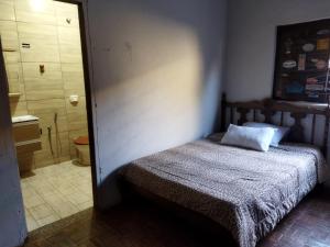 a bedroom with a bed and a bathroom with a shower at Cantinho da Flor in Barretos