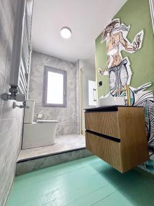 Baño con un mural de una mujer en la pared en Casa Colgada Mirador de Leonor by Gloove, en Cuenca