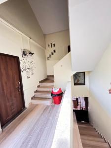 a hallway with stairs and a red trash can at The cozy Inn in Calangute +33 photos