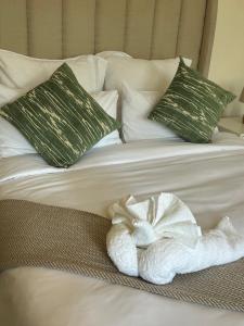 a white towel on a bed with two pillows at The Tranquil Ridge in Hilton