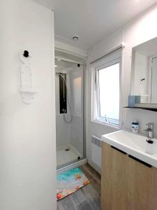 a white bathroom with a sink and a shower at MOBIL HOME à SEIGNOSSE dans les Landes près de la mer in Seignosse