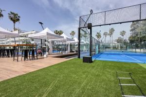 a swimming pool with a tennis court in a building at Dome Beach Marina Hotel & Resort in Ayia Napa