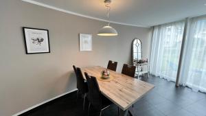 a dining room with a wooden table and chairs at Modern apartment Pilatus view self check-in in Stans