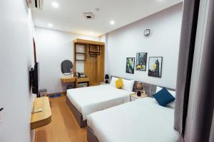 a hotel room with two beds and a television at Sunshine Hotel in Buon Ma Thuot