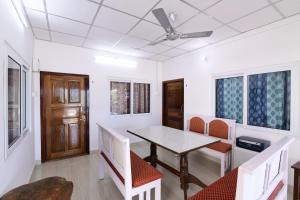 a dining room with a table and chairs and a ceiling fan at Blue Bridge Homes in Port Blair