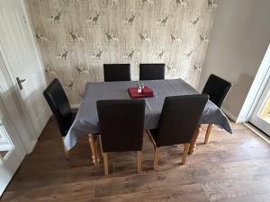 a dining room table with black chairs and a table cloth at Quiet 3 bed semi with off street parking in Bingham +24 photos