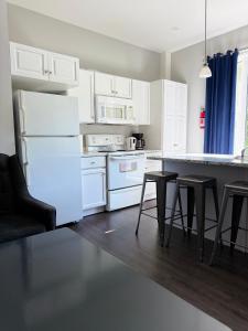 a kitchen with white cabinets and a white refrigerator at Waterfordbridge Apartments - 2 Bedroom Mainfloor in St. John's