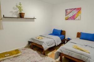 a room with two twin beds and a table at Asia's House in Dahab