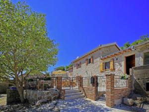 a brick building with a gate and a tree at Holiday Home in Starigrad with Sea View in Starigrad-Paklenica