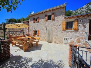 a patio with a wooden table and an umbrella at Holiday Home in Starigrad with Sea View in Starigrad-Paklenica