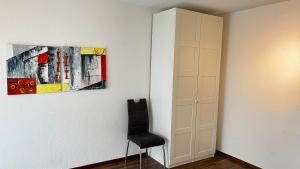 a room with a chair and a painting on the wall at Modern apartment Pilatus view self check-in in Stans