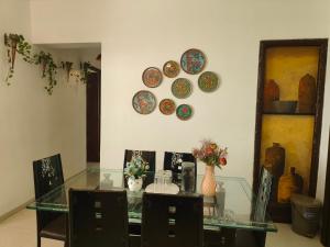 a dining room with a glass table and plates on the wall at Staeg Skyline View 3BHK - 1404 in Indore