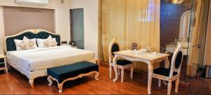 JāmbにあるHotel Mahanayakのベッドとテーブルと椅子のある寝室