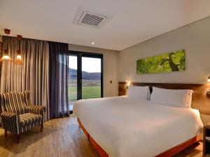 a hotel room with a large bed and a chair at ANEW Resort Vulintaba Newcastle in Newcastle