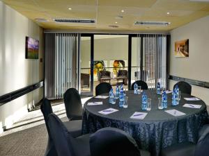 a meeting room with a table and chairs with blue bottles at ANEW Resort Vulintaba Newcastle in Newcastle +67 photos
