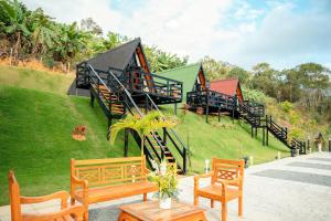 a building with stairs and benches in the grass at Chalet with Private Jacuzzi and View of the Jucu River in Domingos Martins