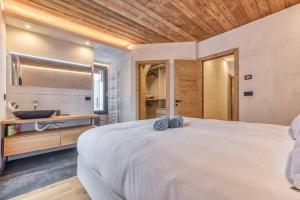 夏蒙尼-勃朗峰Luxurious Chalet Verney - 8 people的一间带一张白色大床的卧室和一间浴室