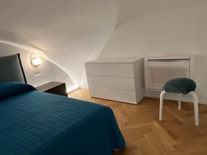 een slaapkamer met een bed, een dressoir en een stoel bij Loft Green Trani in Trani