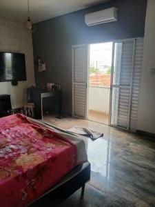 Un dormitorio con una cama y una puerta corrediza de vidrio. en Casa aconchegante, en Salto