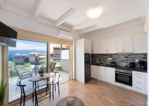 a kitchen and dining room with a table and chairs at Melodia Lefkada Maisonette 3 in Nikiana