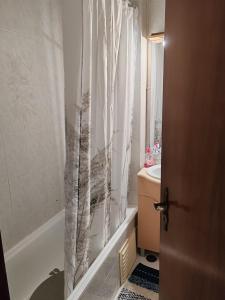 a bathroom with a shower curtain and a sink at Double room in shared house in Santarém