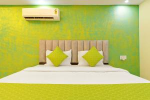 a bedroom with a large bed with green walls at The Crown Inn Madhyamgram in kolkata +7 photos