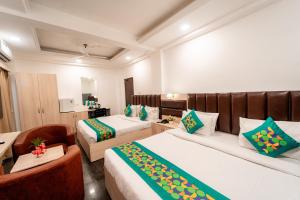 a hotel room with two beds and a chair at Treebo Clarissa Resort Goa in Saligao +39 photos
