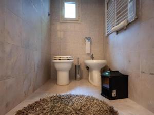 a bathroom with a toilet and a sink and a rug at Casa Margot by Holiday World in Caprarola