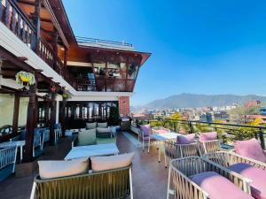 a balcony with chairs and tables on a building at Timber House by Tara Group in Kathmandu