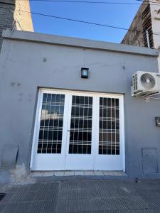 una puerta de garaje blanca con ventanas en un edificio en Central City 2, en San Andrés de Giles