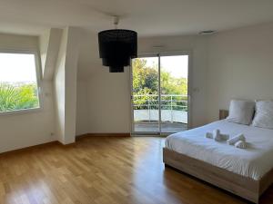 a bedroom with a bed and a large window at Villa Belvédère - Jacuzzi, Billard, Garage & Vue in Le Mans