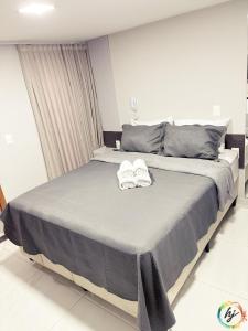 a bedroom with a large bed with two towels on it at Paradise Flat 104 in Nossa Senhora do Livramento